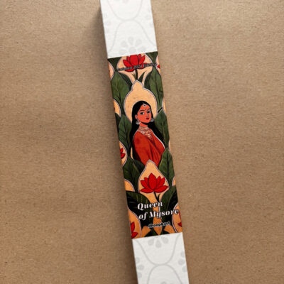Elegante Räucherstäbchen-Verpackung 'Queen of Mysore' von dhoop&art. Die längliche Box zeigt ein künstlerisches Design mit einer indischen Frauenfigur in rotem Gewand und traditionellem Schmuck, umgeben von grünen Blättern und roten Lotusblüten auf beigefarbenem Hintergrund. Die Box hat weiße Enden mit dezentem Blumenmuster.