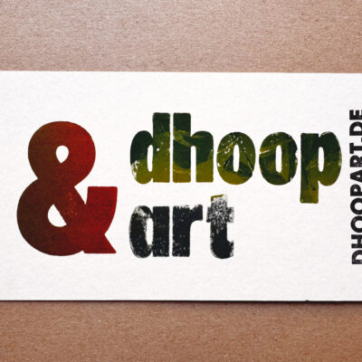 Visitenkarte im Letterpress-Druck. Logo 'dhoop&art' mit orangefarbenem Kaufmanns-Und, grünem 'dhoop' und blauem 'art'. Domain 'DHOOPART.DE' vertikal in schwarzer Super Groteske. Auf weißem Büttenpapier handgedruckt.