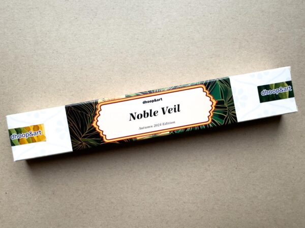 Noble Veil Räucherstäbchen, Herbst Edition 2024 - elegantes Design mit goldumrandeter Beschriftung auf weißem Grund, umgeben von kunstvollen dunkelgrünen Blattmotiven.